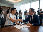 足球转会窗口新闻现场，球员与俱乐部高层签订合同的签约瞬间